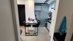 Una cucina moderna con zona pranzo, caratterizzata da un'isola centrale con sedute, un frigorifero e un lavello.
