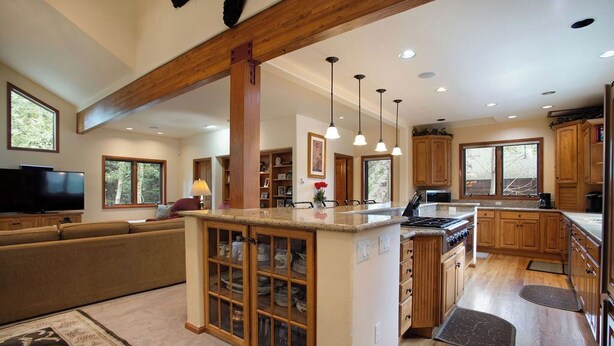 A spacious kitchen with wooden cabinets, a central island with a sink, and pendant lighting. - Streamside Lane: Riverside Frisco Home, Dog Friendly, Near Slopes (Frisco)