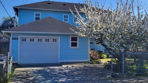 A two-story house with a blue exterior and a white garage door. - Arcata Sunset Townhouse (Arcata)