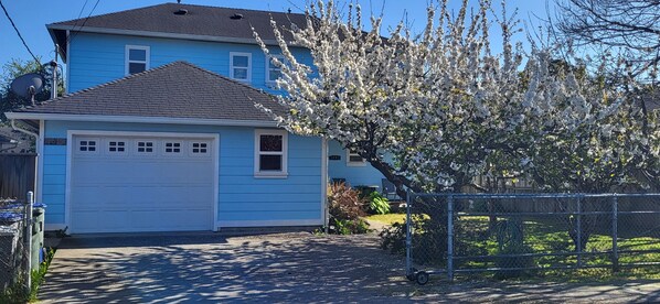 A two-story house with a blue exterior and a white garage door.