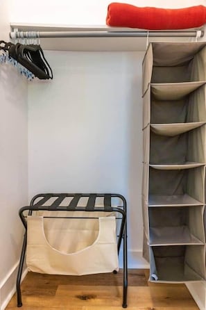 Un placard avec une tringle pour suspendre les vêtements, un porte-chaussures et un meuble de rangement doté de plusieurs compartiments.