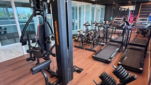 Una palestra con attrezzature per esercizi, tapis roulant e macchinari per pesi.