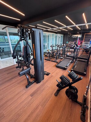 A gym with exercise equipment, treadmills, and weight machines. - Essenza Porto de Galinhas - Flat na Praia (Ipojuca)