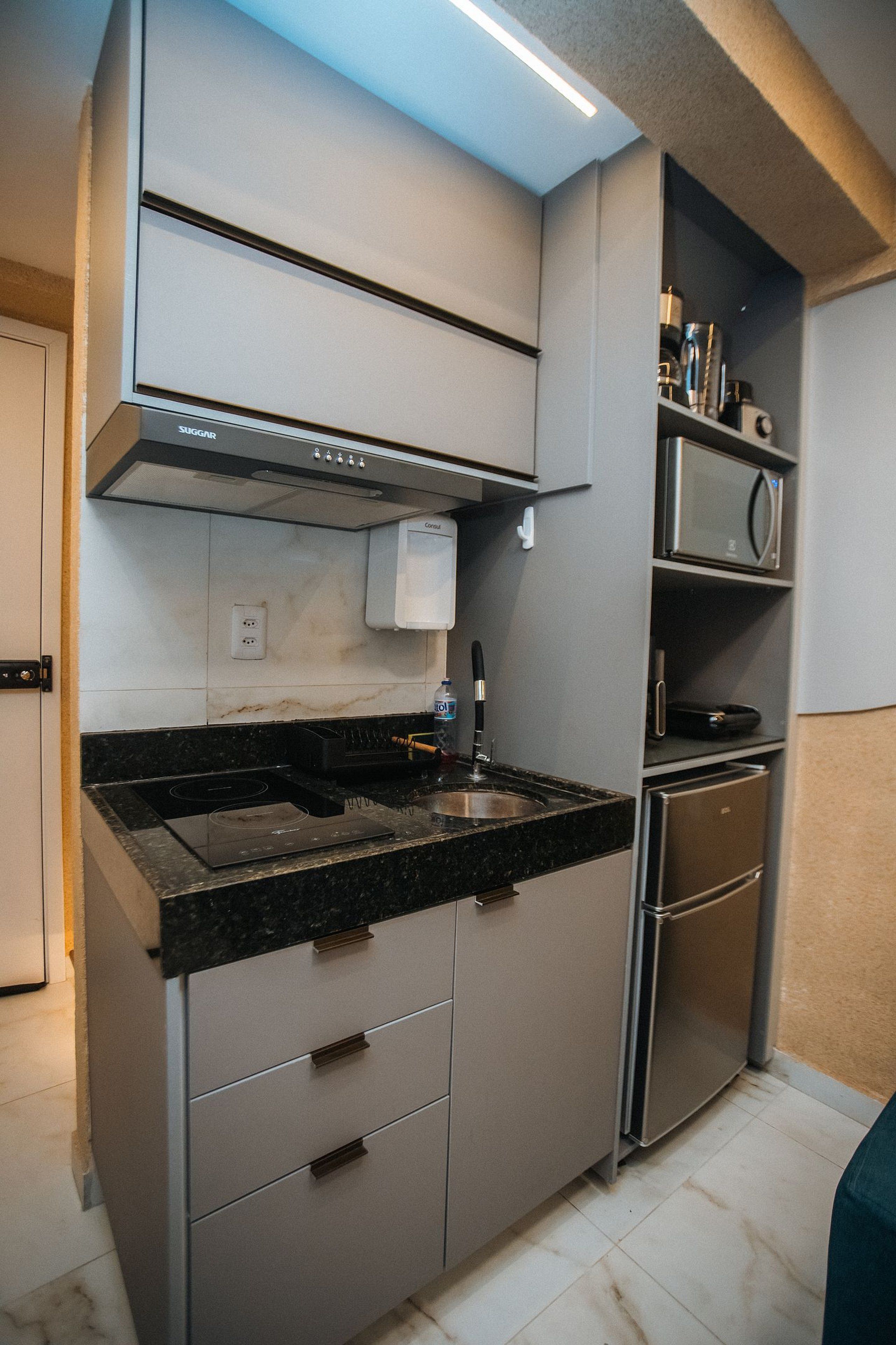 Een moderne keuken met een ingebouwde kookplaat, magnetron en roestvrijstalen apparatuur.