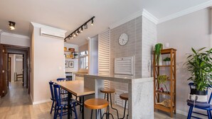 A modern kitchen with a central island, bar stools, and a clock on the wall. - Apt With Balcony and BBQ 30m From the sea Rdm0101 (Itapema)