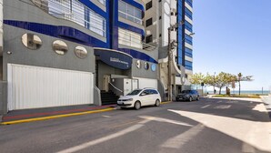 A modern building with a blue and white facade, a gated entrance, and a car parked in front. - Apt With Balcony and BBQ 30m From the sea Rdm0101 (Itapema)