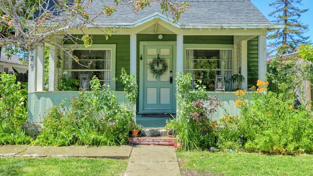 A green house with a front porch, a door with a wreath, and a number '29' on the side. - Charming Arroyo Cottage walking distance from Old Town Arroyo (Arroyo Grande)