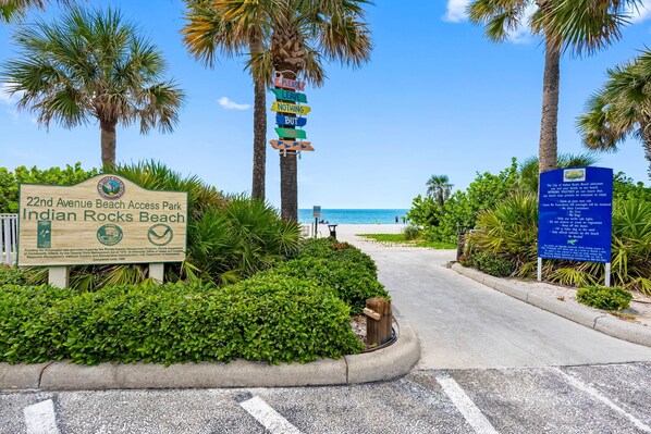 Un panneau indiquant l’accès à la plage du parc situé sur la 22e avenue, à Indian Rocks Beach, avec une vue sur la plage en arrière-plan.