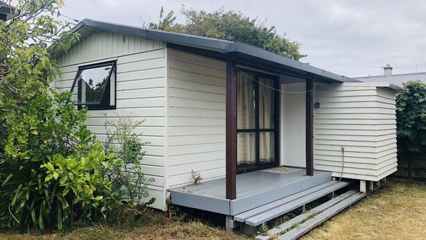 A single-story mobile home with a covered porch and a small window. - 2 double beds including 1 double sofa bed Garden Chalet, 7 Rangiatea Road, Epsom, Auckland (Auckland)