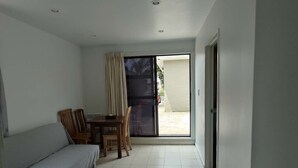 A room with a sofa, a dining table with chairs, and a sliding glass door leading to an outdoor area. - 6 Beds including 4 Double Beds and 2 Sofa Bed Garden Chalet, 8 Renton Road, Mt Albert, Auckland (Auckland)