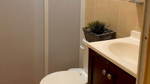 A bathroom with a toilet, a sink, and a decorative plant in a basket. - 10 Coleguita in Isla Mujeres (Isla Mujeres)