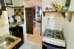 A kitchen with a stove, sink, and a checkered backsplash. - 05 Conchi Abajo in Isla Mujeres (Isla Mujeres)