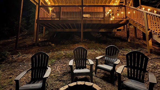 Una terraza de madera con mobiliario exterior y una chimenea.