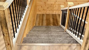 Una escalera de madera con un rellano alfombrado.