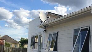 A single-story mobile home with a satellite dish, a front door, and a small porch. - 4 Beds including 2 Double Beds and 2 Sofa Beds up to 8 People, House, 22B Pererika St, Rotorua (Rotorua)
