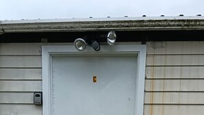 A white door with a small step leading up to it, a mailbox on the left, and a metal roof above. - 3 Beds including 1 Double Bed, 2 Single Sofa Beds Garden Chalet, Unit C, 9 Steeles Lane (Rotorua)