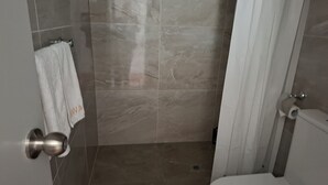 A bathroom with a shower, a toilet, and a towel rack with a white towel. - 5 Beds including 1 Double Bed, 2 single Beds, 2 Double Sofa Beds, Suite 4 (Auckland)