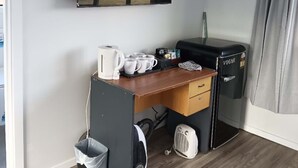 A compact kitchenette with a built-in fridge, a small sink, and a microwave. There is a window above the counter, and a TV mounted on the wall. - 4 double and 2 Sofa Beds chalet (Rotorua)