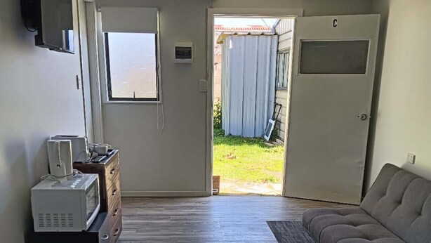 Un dormitorio con cama, sofá, escritorio y una ventana.