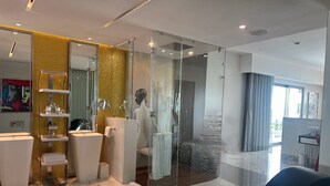 Une salle de bain moderne avec une douche à parois de verre, un meuble-lavabo avec un miroir et un grand miroir mural.