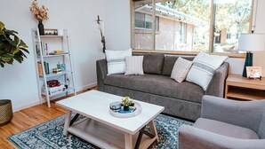 A living room with a grey sofa, white coffee table, and a patterned rug. - Spacious & Cozy Home near Olde Town Arvada (Arvada)