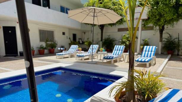 Un espace piscine équipé de chaises longues et de parasols.