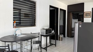 Eine kleine Küche mit Esstisch, Mikrowelle und Kühlschrank.