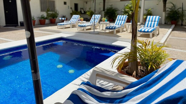 A pool area with lounge chairs and umbrellas.
