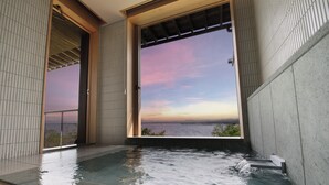 Un jacuzzi con vista al océano al atardecer.