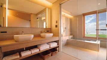 Un baño moderno con dos lavamanos, un espejo grande y una bañera.