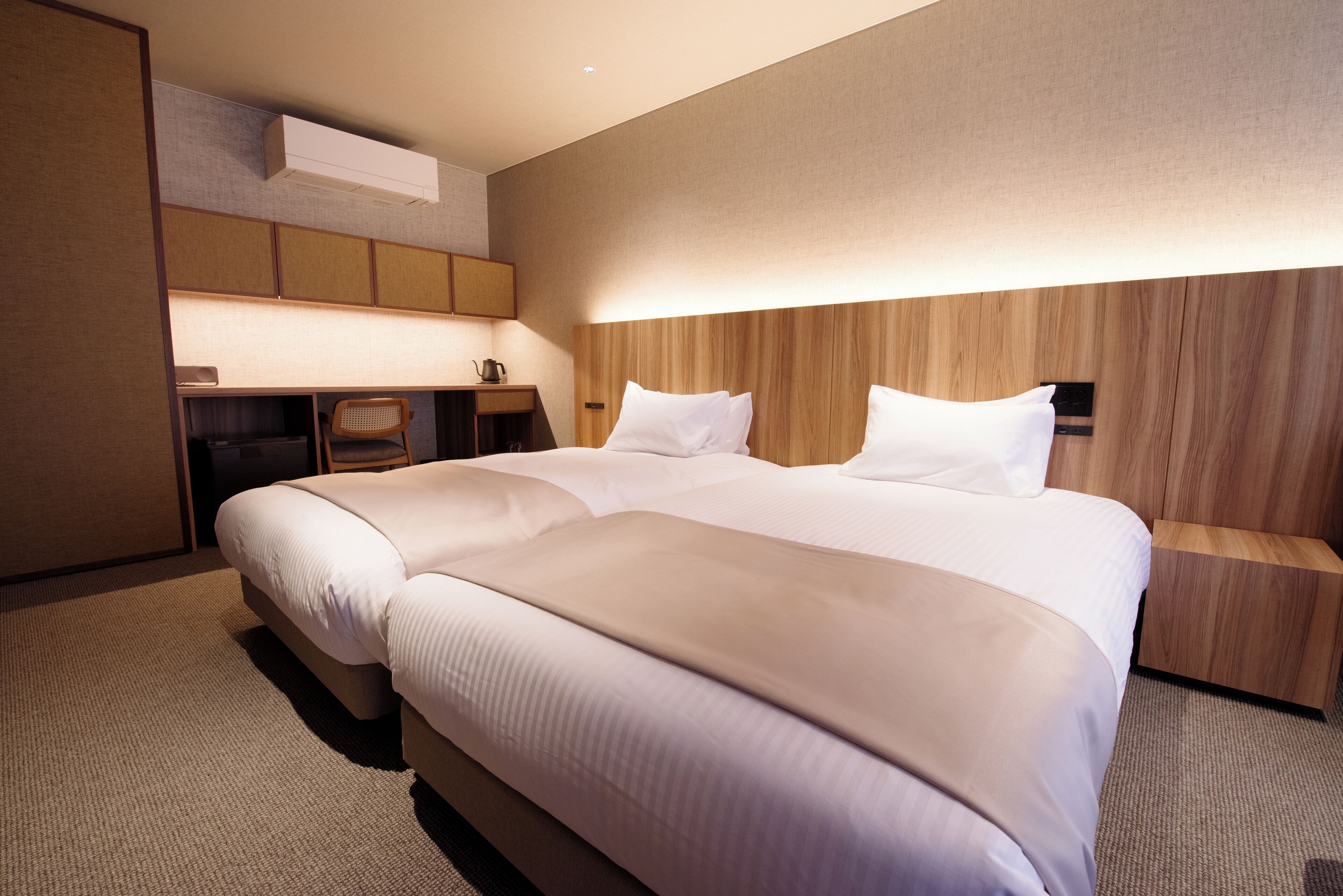 Ein modernes Hotelzimmer mit einem großen Bett, einem Schreibtisch und einem Sessel.