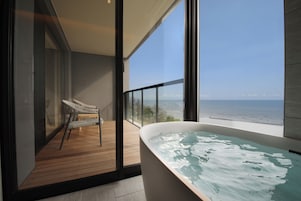 Un baño moderno con una bañera grande y vistas a la playa.