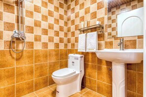 A bathroom with a toilet, a sink, and a shower.