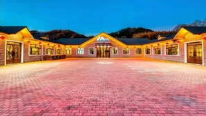 A hotel with a symmetrical facade, a central entrance, and a paved courtyard.