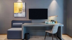 A modern room with a grey sofa, a desk with a chair, a flat-screen TV, and a framed picture on the wall. - Shanghai Lujiazui BaBaiBan LANOU Hotel (Shanghai)