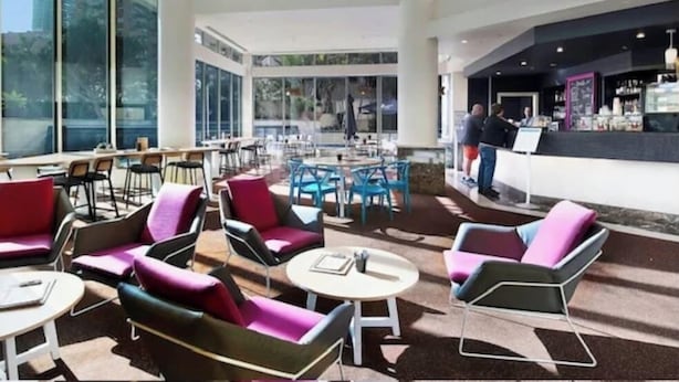 A spacious indoor area with multiple seating arrangements, a bar area, and large windows providing views of the cityscape. - Queen Studio | Beach and Tram at Doorstep @ Legend (Surfers Paradise)