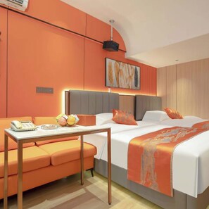 A modern hotel room with a large bed, a sofa, and a desk with a telephone and fruit basket. - Chengxing Hotel Apartment (Shenzhen)