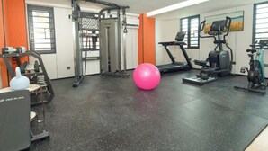 A gym with exercise equipment, a pink exercise ball, and a treadmill. - Chengxing Hotel Apartment (Shenzhen)