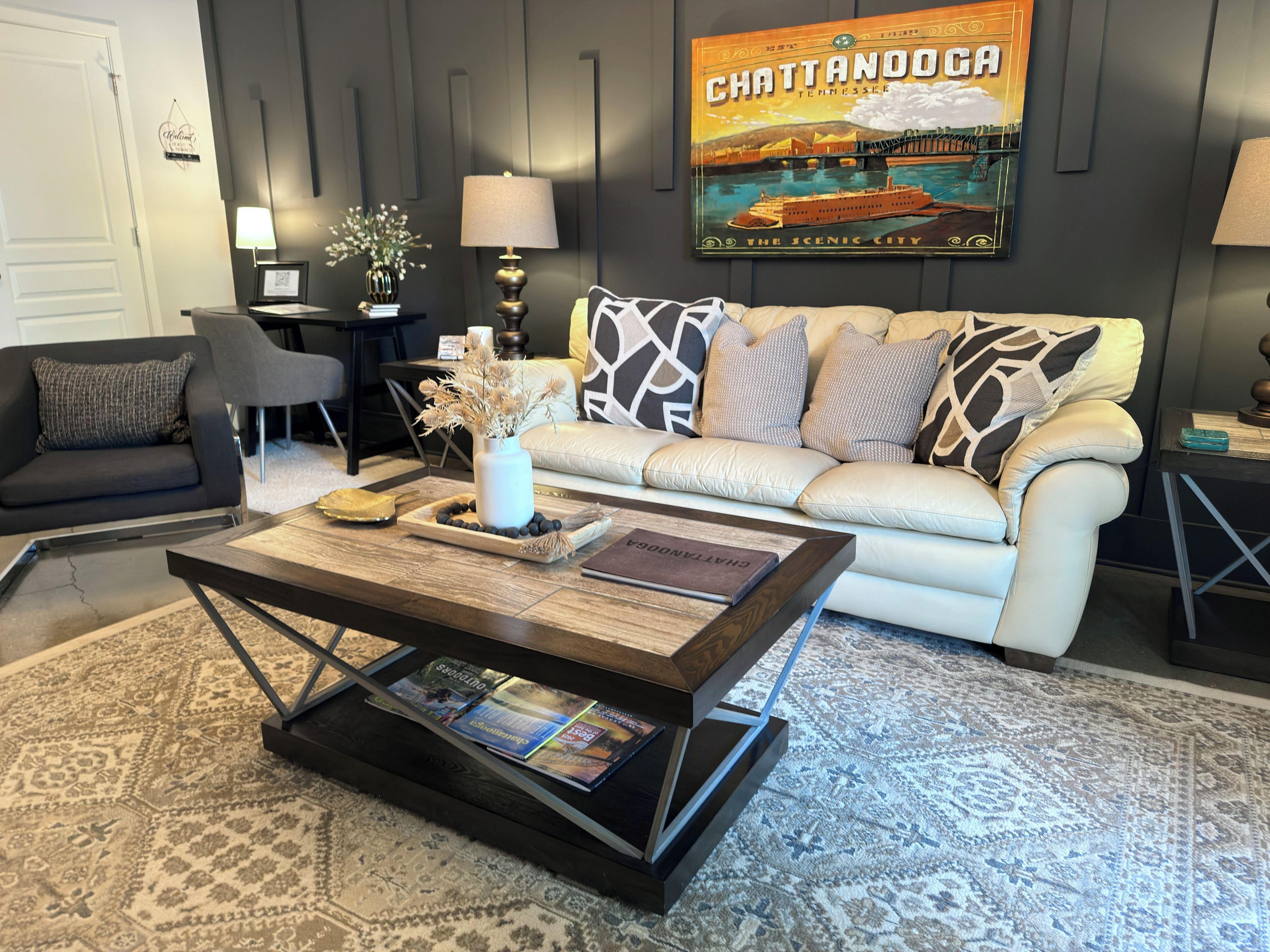 Una sala de estar moderna con sofá, una mesa de centro y un cuadro enmarcado de Chattanooga.