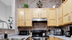 A kitchen with wooden cabinets, a stainless steel stove, a microwave, and a sink. -     Spotless Luxury Retreat. Walk to Food & Fun. King Bed. Free Parking (Chattanooga)