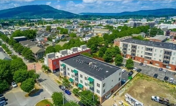 An aerial view of a residential area with multi-story buildings, roads, and greenery.