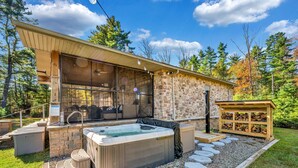 A modern outdoor hot tub area with stone walls and a wooden deck.