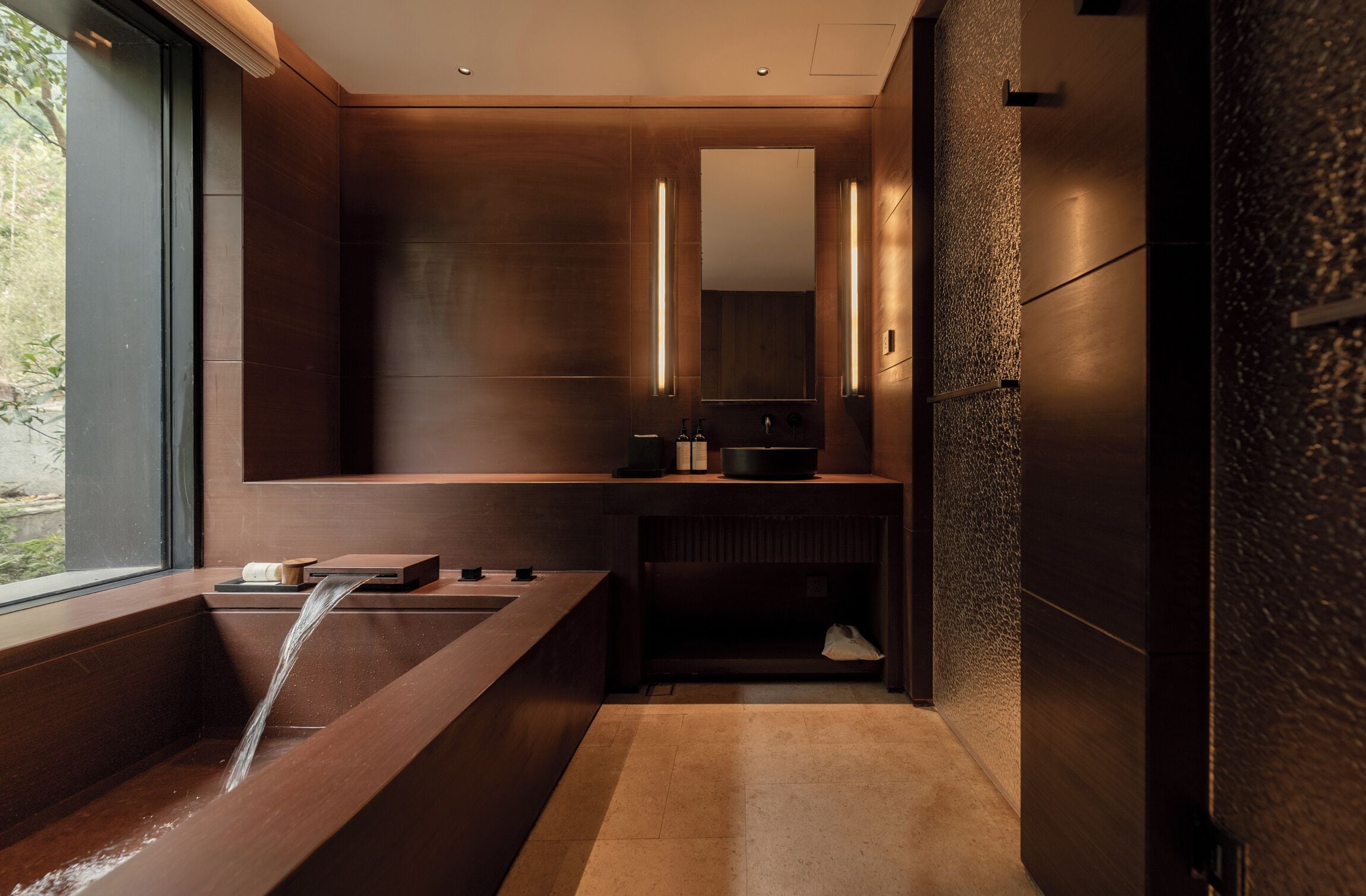 Un baño moderno con una bañera grande, un lavabo y un espejo.