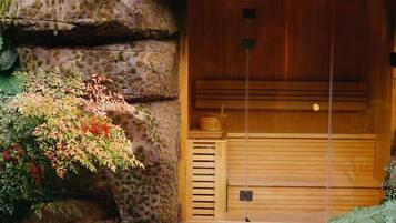 Entrada a una sauna de madera tradicional con puerta de madera y un pequeño banco interior.