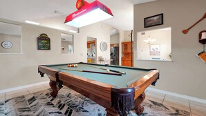 A pool table with balls, a clock, and a framed picture on the wall. - Spacious 3BR Home, Gym, Pool Table, Central Location (Deltona)