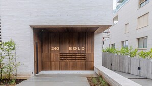 A modern building with a large wooden door labeled "240 BOLD". - Blueground | Kirchberg, balcony, nr Parc de Merl (Luxembourg)