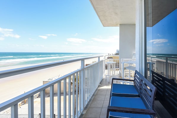 Ein Balkon mit Blick auf Strand und Meer.