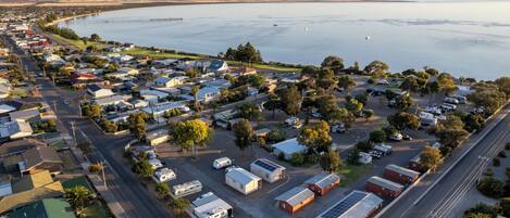 A coastal town with a marina, residential buildings, and a road leading to the water.
