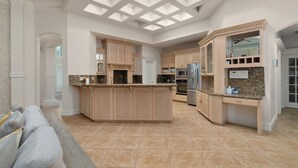 A spacious kitchen with a central island, built-in cabinetry, and a skylight. - Valley Gateaway! Pool House (Mission)