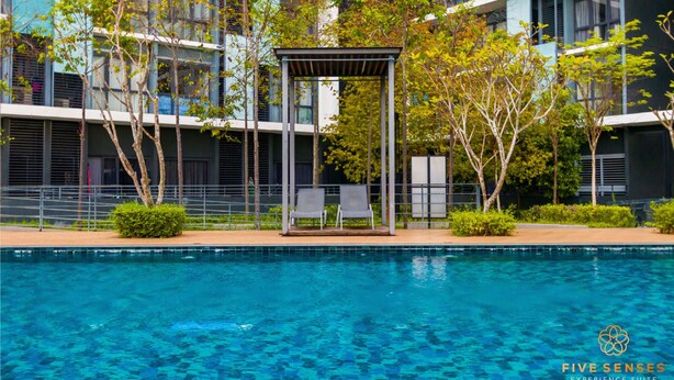 A modern building with a pool, two lounge chairs, and a pergola structure. - KIP Core Soho Suite by Five Senses (Sepang)